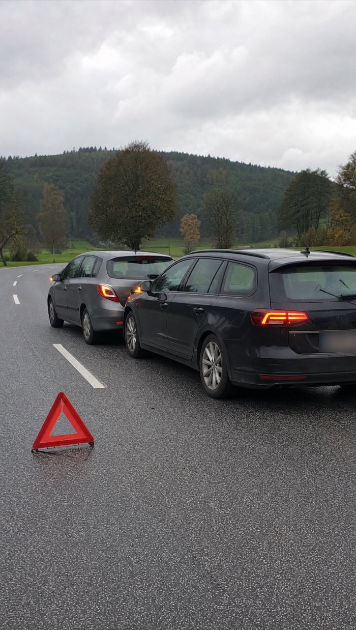 Auffahrunfall auf einer Landstraße: zwei Autos, davor ein aufgestelltes Warndreieck